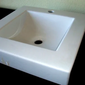 Lavabo de sobre encimera cuadrado de cerámica blanca.