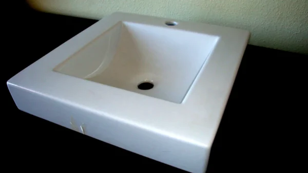 Lavabo de sobre encimera cuadrado de cerámica blanca.