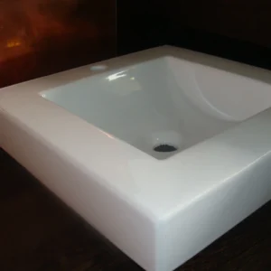 Lavabo de sobre encimera cuadrado de cerámica blanca.